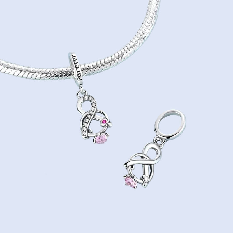 Side view of the infinity knot dangle charm highlighting zirconia accents and polished silver finish