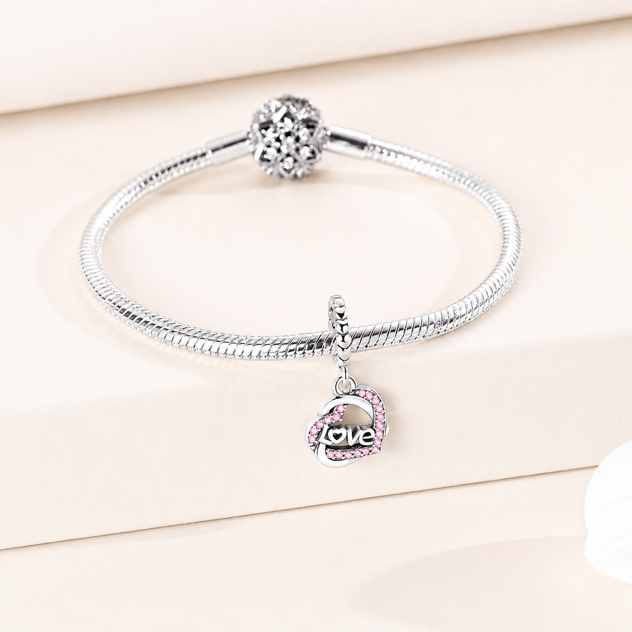 Side view of the heart-shaped dangle charm featuring pink zirconia and polished silver details | Asttery