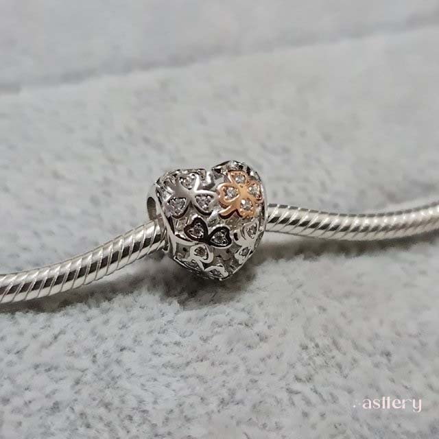 Intricate clover charm in silver and rose enamel with delicate sparkle | Asttery