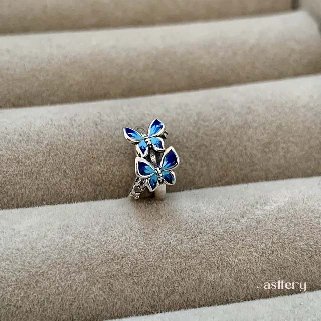 Sterling silver spacer charm with fluid design, blue enamel butterflies, and subtle brilliance | Asttery