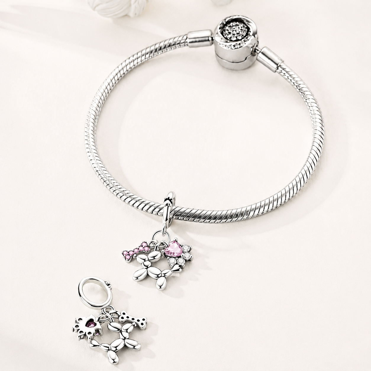 Top view of Balluvi charm showing paw-print bail, three dangling motifs, and sparkling CZ stones | Asttery