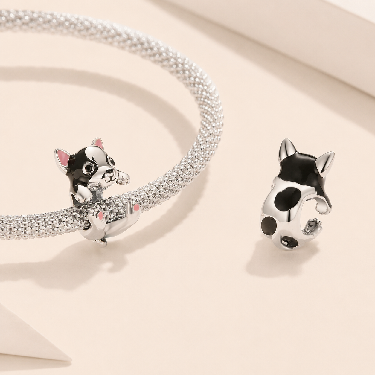 Crafted in 925 sterling silver with delicate black, white, and soft pink enamel, this charm portrays a sweet little dog | Asttery