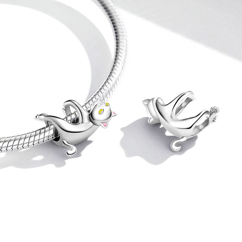 Stylized silver charm of an upside-down cat with lifted paws and serene expression, detailed with enamel, Asttery