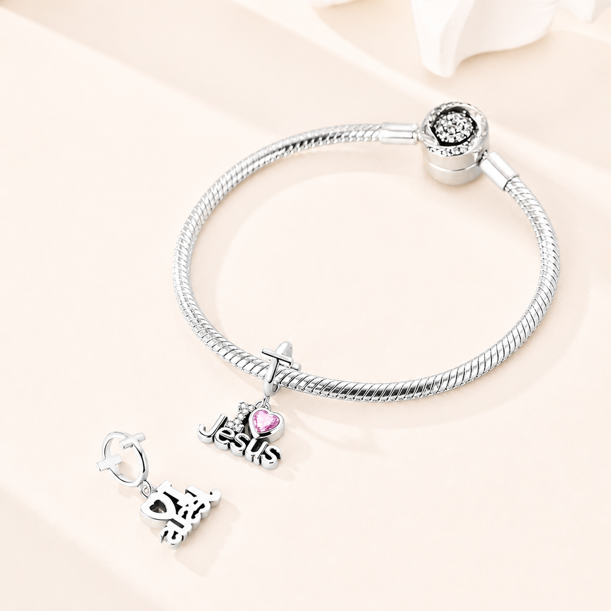 Amoria Faith dangle charm styled on a silver bracelet, symbolising love, devotion and spiritual fa