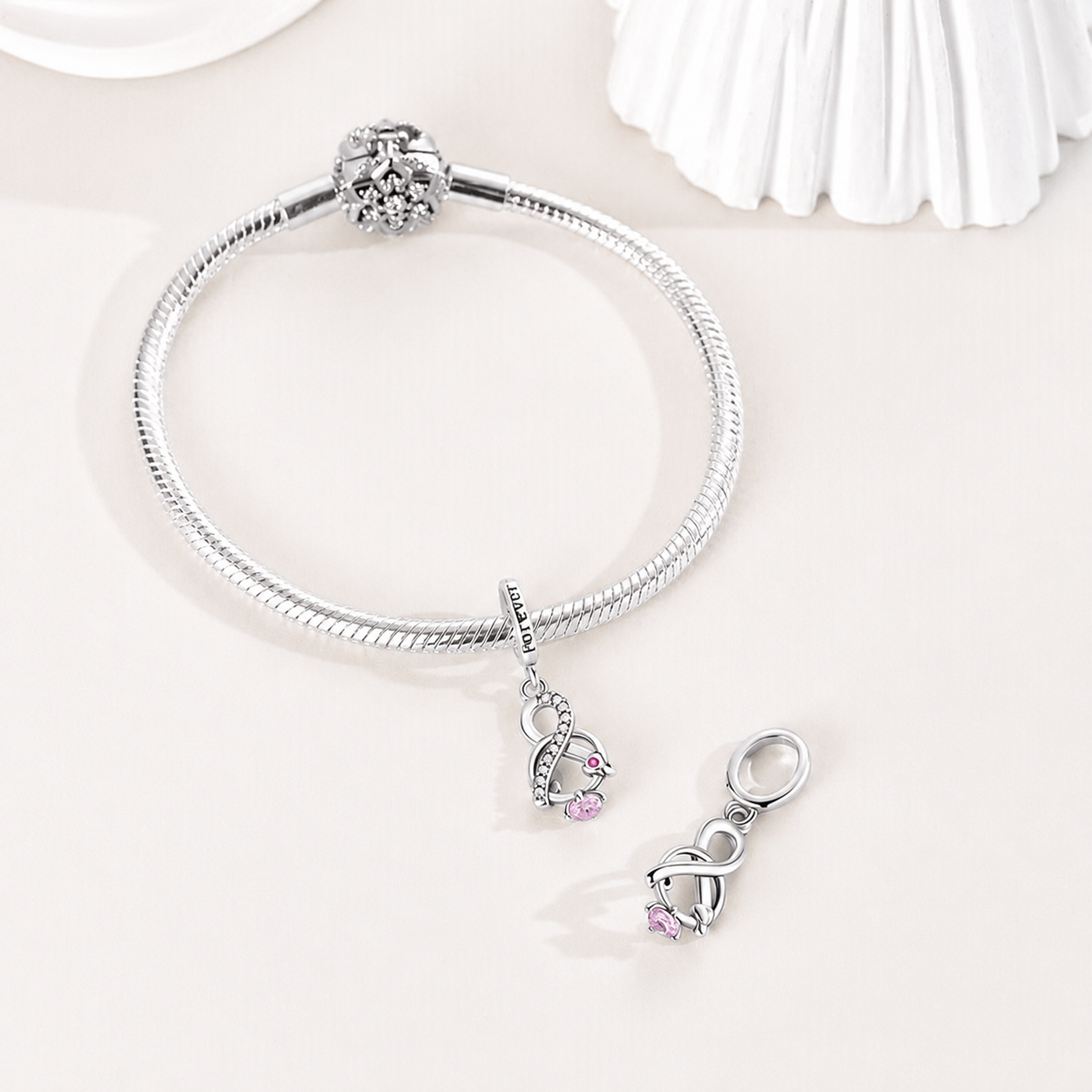 Aethelin infinity knot dangle charm styled on a silver bracelet | Asttery