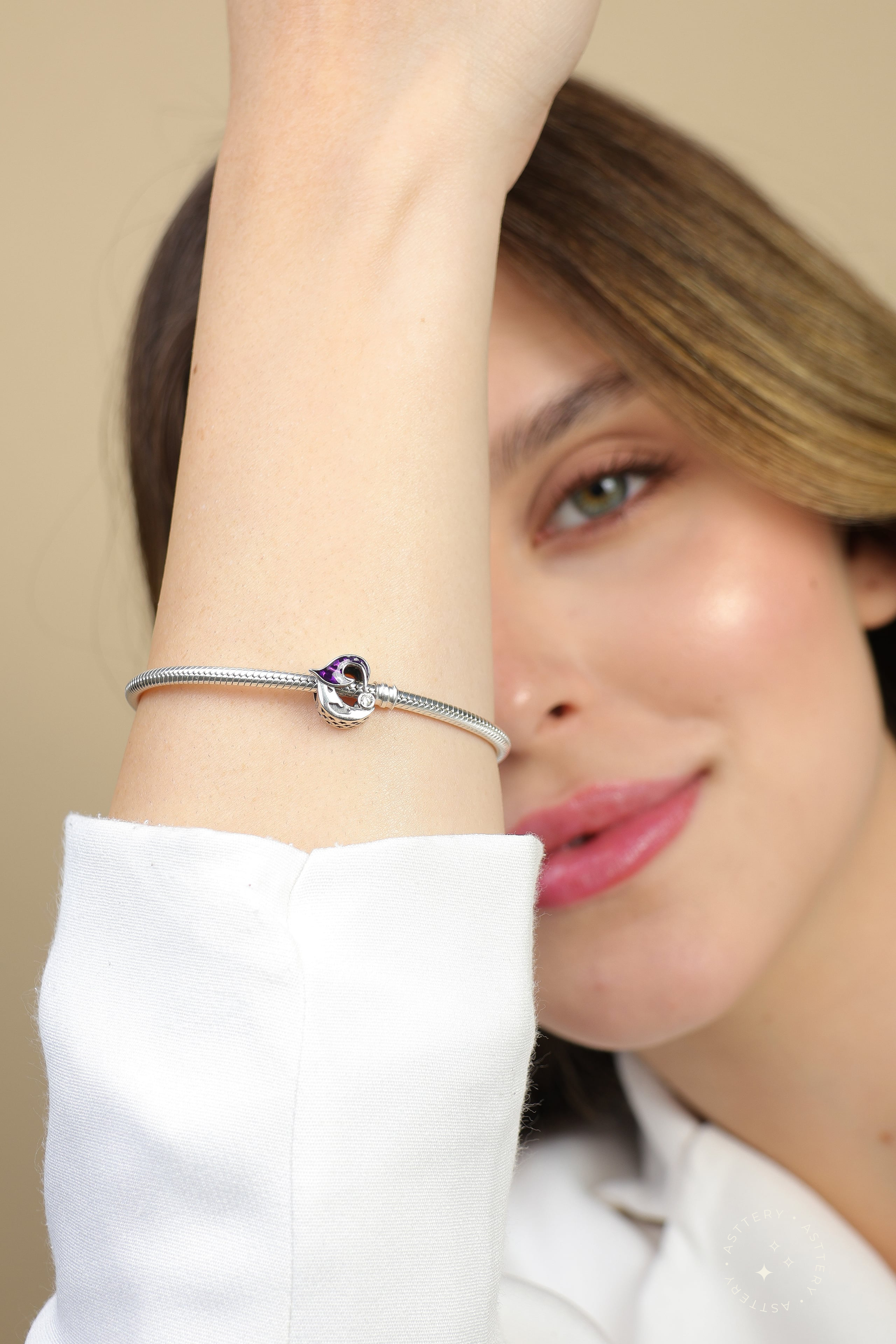 Model's wrist adorned with the Velanth Moon charm on a bracelet , a quiet statement of mystery and elegance, Asttery