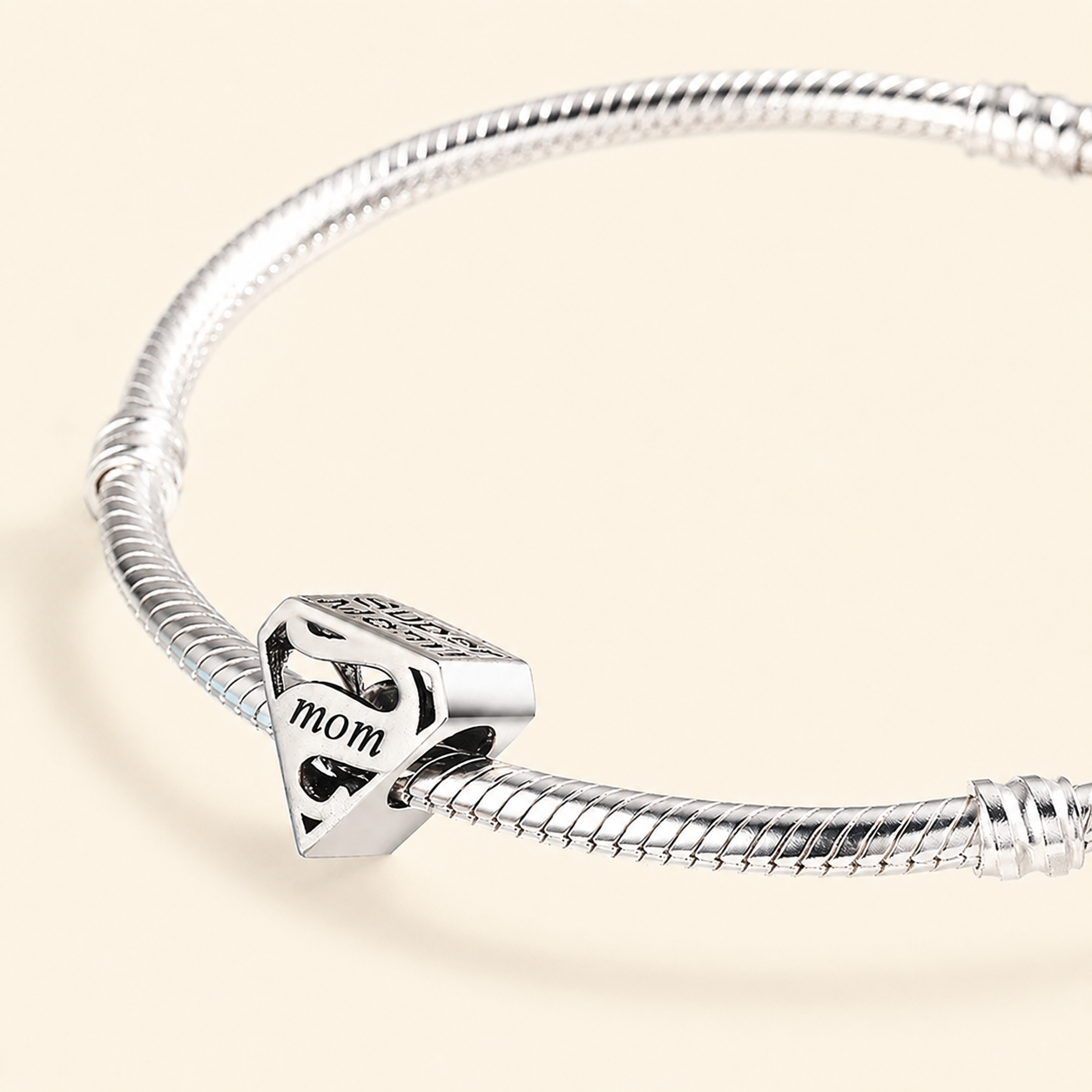 Side view of the sterling silver Mom emblem bead showing the sculpted shield shape | Asttery