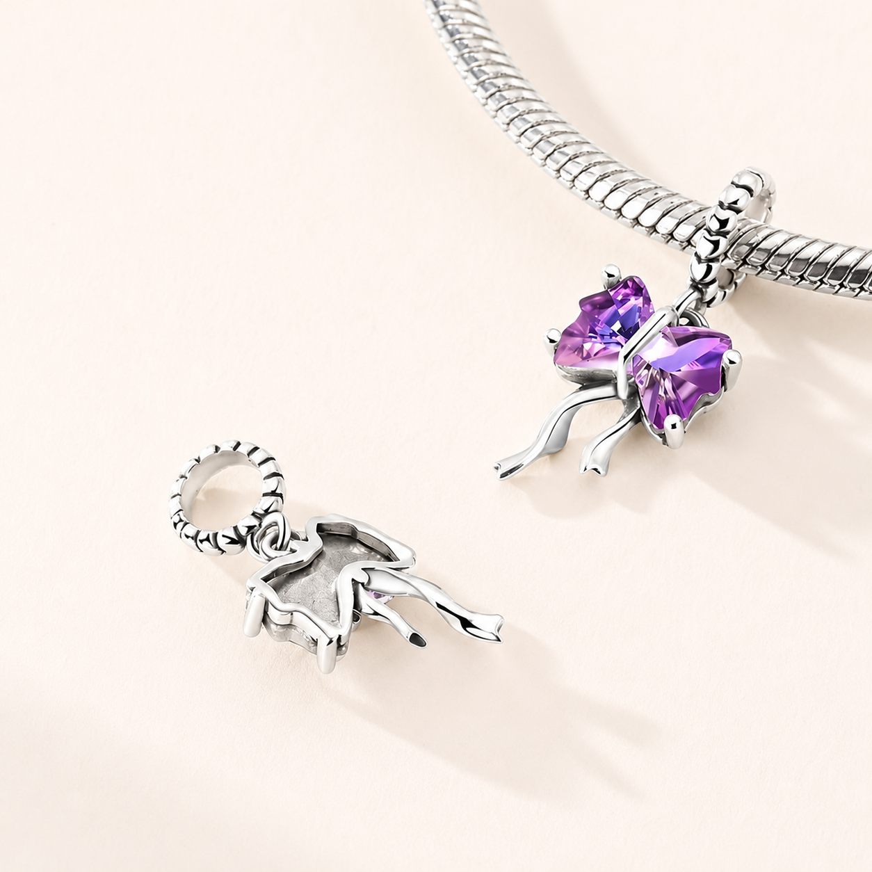 Ametys Bow dangle charm styled on a silver bracelet, representing elegance, softness and refined beauty |  Asttery