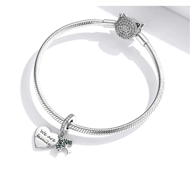 Delicate silver charm representing the Tree of Life with intertwined roots and branches,  Asttery
