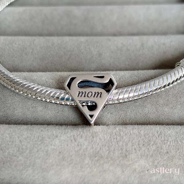 Super Mom emblem charm bead styled on a bracelet, symbolising strength and love | Asttery